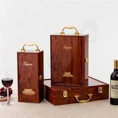 three wooden boxes with wine bottles and glasses next to each other on a counter top