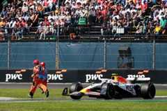 Marshals run across the track in front of Liam Lawson's Racing Bulls F1 car