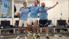 Julian Alvarez, Jack Grealish and Manchester City staff member Brandon Ashton celebrate the title win in the dressing room