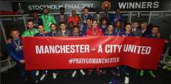 The Manchester United players pose with a banner for those who lost their lives in the Manchester attack