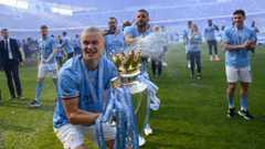 Manchester City striker Erling Haaland celebrates with the Premier League trophy