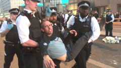 Etienne Stott is carried by police after being arrested