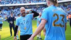 Manager Pep Guardiola celebrates on the pitch after leading Manchester City to another trophy