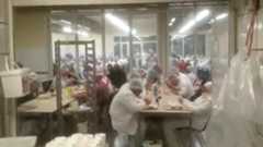 Footage from inside the canteen shows workers sitting together without social distancing