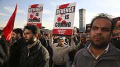 Iranian demonstrators hold anti-Saudi placards