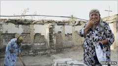 An Uzbek woman in the ruins of her house