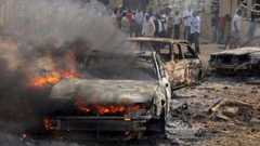A car burns at the scene of a bombing at St Theresa Catholic Church near Abuja, 25 December 2011