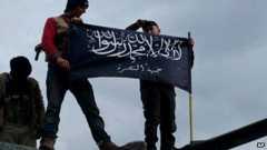 Members of the al-Nusra Front raise its banner above a military base in Idlib province (11 January 2013)