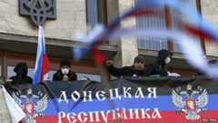 Pro-Russia protesters hang a banner as they storm the regional government building in Donetsk April 6, 2014