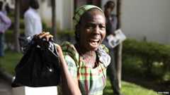 A bystander reacts as she sees victims of a bomb blast arriving at the Asokoro General Hospital in Abuja (14 April 2014)