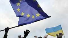 Students wave flags of the European Union and Ukraine as they shout slogans during a rally of the opposition in the western Ukrainian city of Lviv on 5 December 2013