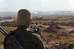 A Kurdish fighter monitors a road in Diyala province, Iraq, 14 June