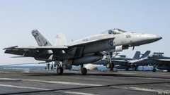 A US Navy F/A-18F Super Hornet landing aboard the USS George HW Bush after conducting air strikes on Islamic State militants - 23 September 2014