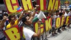 Activists chant and hold placards outside the Chinese embassy in Manila on 11 May 2012