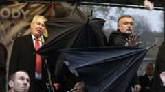 Security guards open umbrellas as people throw eggs and tomatoes at the President of Czech Republic, Milos Zeman in Prague, Czech Republic on 17 November 2014