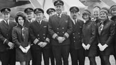 Captain Douglas Redrup of BOAC stands with members of his flight crew before taking off on the first scheduled flight.
