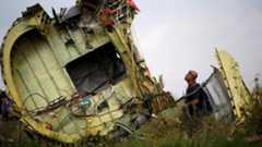 An investigator inspects the wreckage of flight MH17