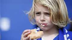 Fan eats his free Leicester City doughnut