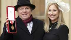 The musician was accompanied by his daughter Shana Morrison at Buckingham Palace