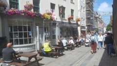 People sitting outside a pub having a drink.