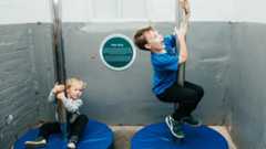 Young boys sliding down fire poles