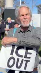 A man is holding a small handkerchief that says "ICE out."
