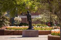 The Torchbearer Statue stands tall as spring flowers bloom in Circle Park