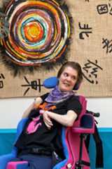 Steffi Kratzer sitzt in ihrem Rollstuhl in der Wohnküche vor ihrer Wohnung.