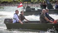 Mehrere Personen fahren in zwei Motorbooten auf dem Wasser.