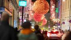 Eine belebte Straße in Wien ist mit Weihnachtsschmuck geschmückt.