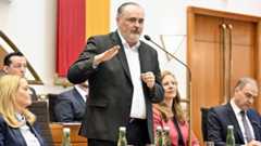 Ein Mann in einem Anzug spricht vor einem Publikum.