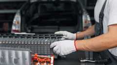Serviceman repairs electric battery pack of hybrid car.