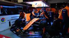 Mechaniker arbeiten in der McLaren-Box an dem Auto.