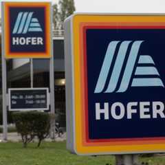 Ein Schild mit dem Hofer-Logo vor einer Hofer-Filiale.