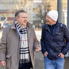 Zwei Männer unterhalten sich auf der Straße.