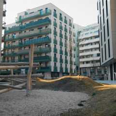 Ein Spielplatz mit Klettergerüst vor modernen Wohnhäusern.