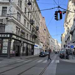 Blick auf die Löwen-Apotheke in Wien mit Passanten und Straßenverkehr.