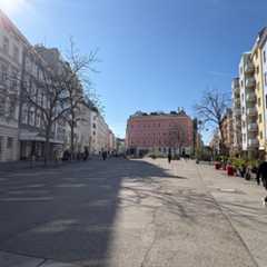 Eine belebte Straße in Wien mit Passanten und architektonisch vielfältigen Gebäuden.