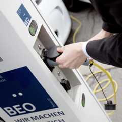 Eine Person schließt ein Elektroauto an einer BEO-Ladestation an. Eine Person schließt ein Elektroauto an einer BEO-Ladestation an.