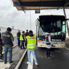 Polizisten und Zollbeamte kontrollieren einen Reisebus an einem Grenzübergang.