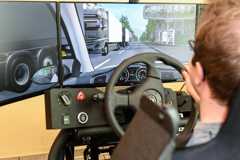 Ein Mann sitzt an einem Fahrsimulator