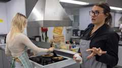 Radikaalin toivon ytimessä Ruusuvuoren yläkoulussa Vantaan Korsossa on se, että saa itse tehdä ja tarttua asioihin. Taustalla Joy Dombret paistaa lettuja. Etuajalla kotitalousopettaja Helena Hurme.