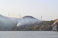 岡山市南区飽浦地区の山林火災。４日目を迎えても煙を上げて延焼を続けている＝２６日午前７時３分