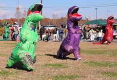 恐竜の着ぐるみ姿で走る出場者
