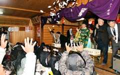 盛大に餅がまかれ、地域住民らが新年の幸せを祈った年結祭＝鶴岡市・八幡神社