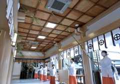 ささ竹ですすを払い、新年を迎える準備をする巫女＝１３日、鹿児島市の照国神社