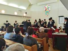 広島三育学院高校のハンドベル演奏に耳を傾ける来場者=13日、奈良市平松1のセブンスデー・アドベンチスト奈良キリスト教会