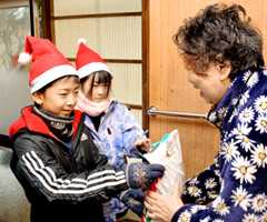 独居高齢者に一足早いクリスマスプレゼントを届けた子どもたち＝庄内町清川地区