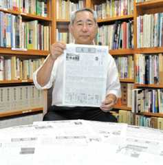 有隣堂の情報紙「有鄰」の最終号となる600号を手に持つ岡沢基博さん。手前には「有鄰」のバックナンバーが並ぶ=横浜市戸塚区