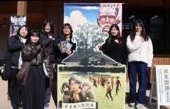 施設入り口に設置された登場人物のパネルと記念撮影する大学生＝日田市淡窓の咸宜園跡